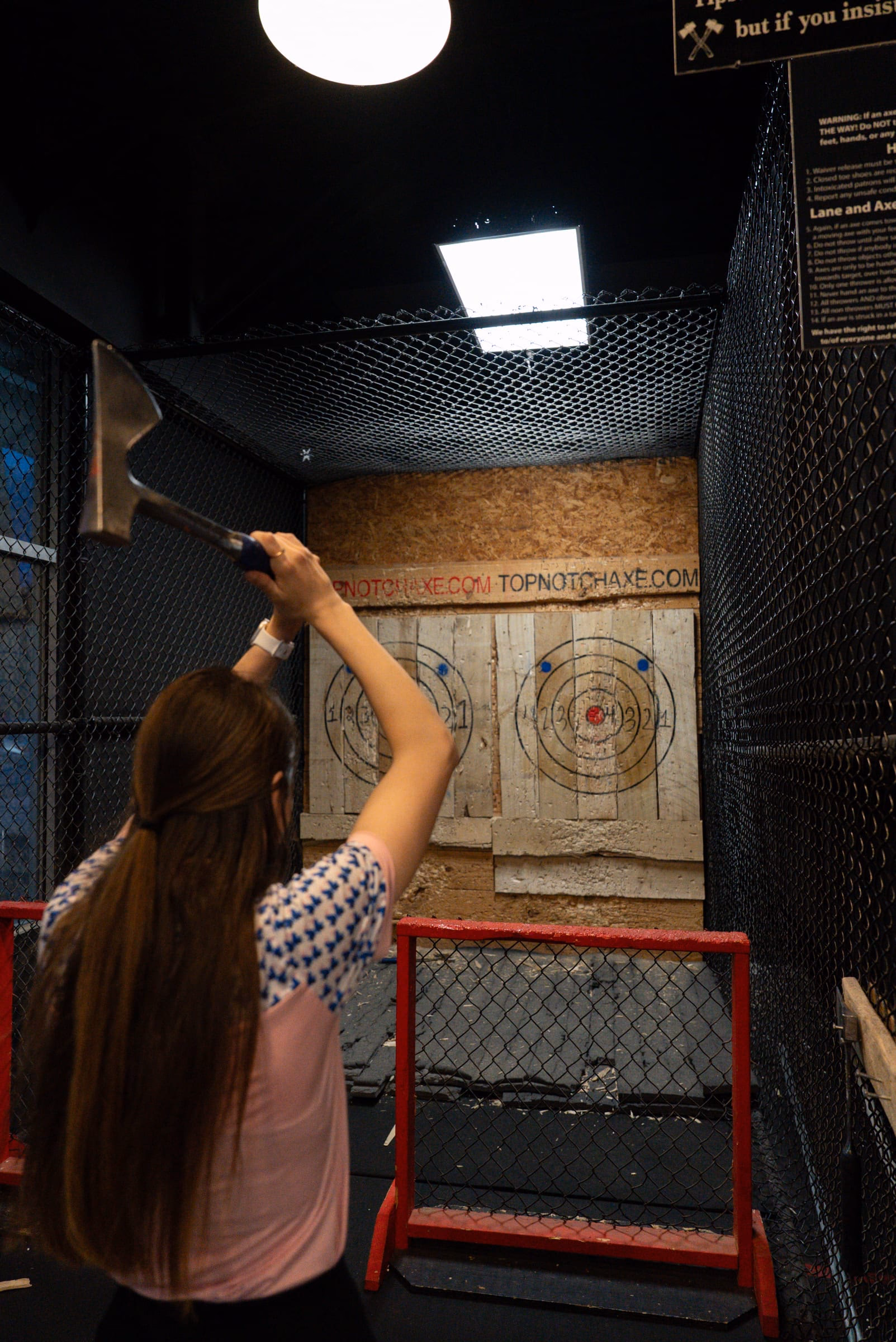 A guest mid-throw in the axe lanes at Top Notch Axe Throwing