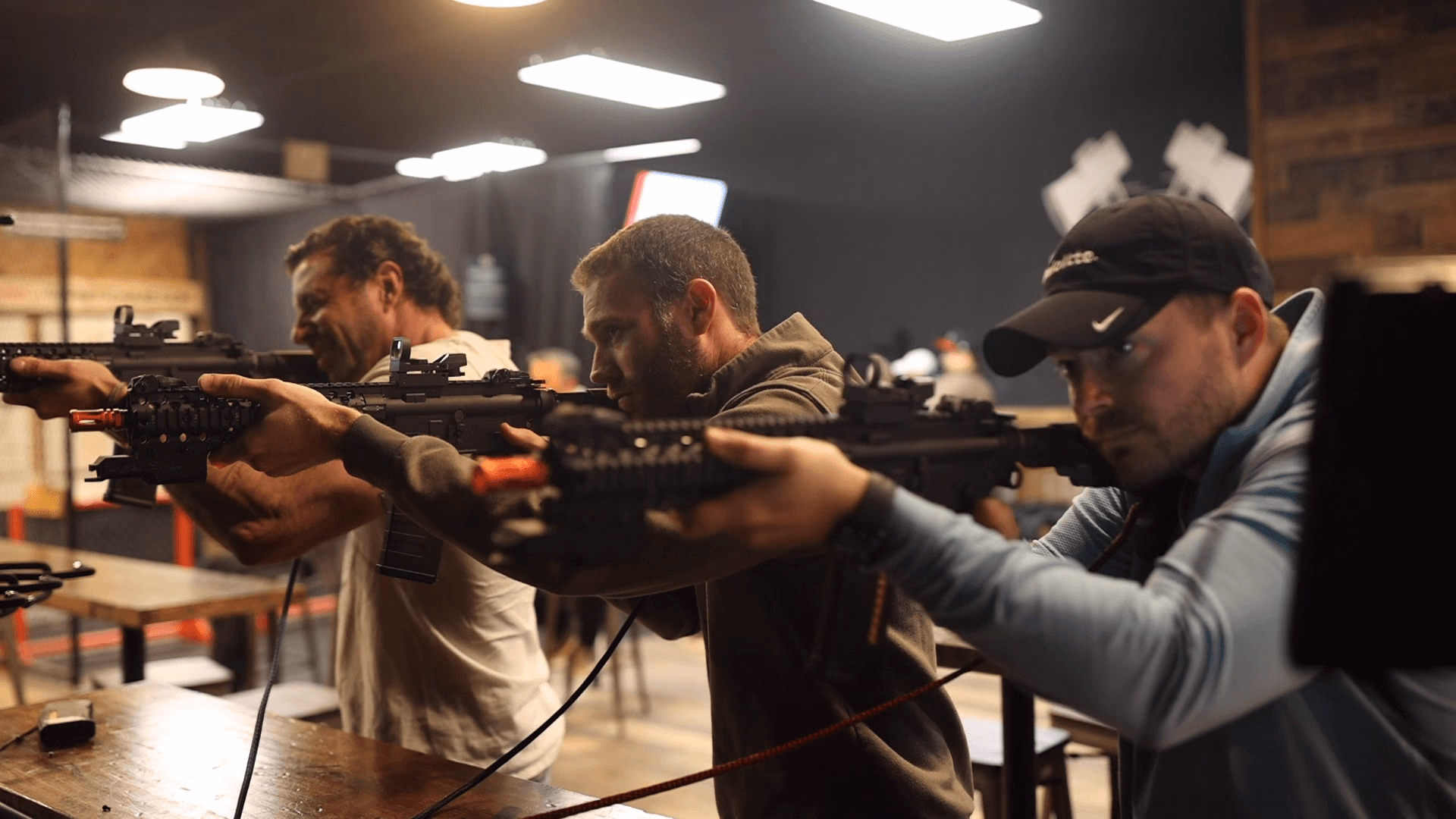 A group shooting side by side at the Top Shot BB gun bar