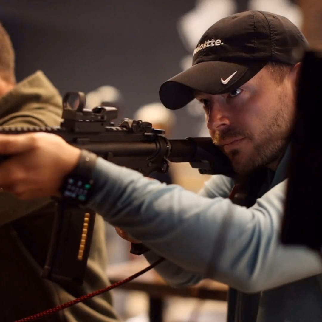 A guest sighting down an AR-style BB rifle