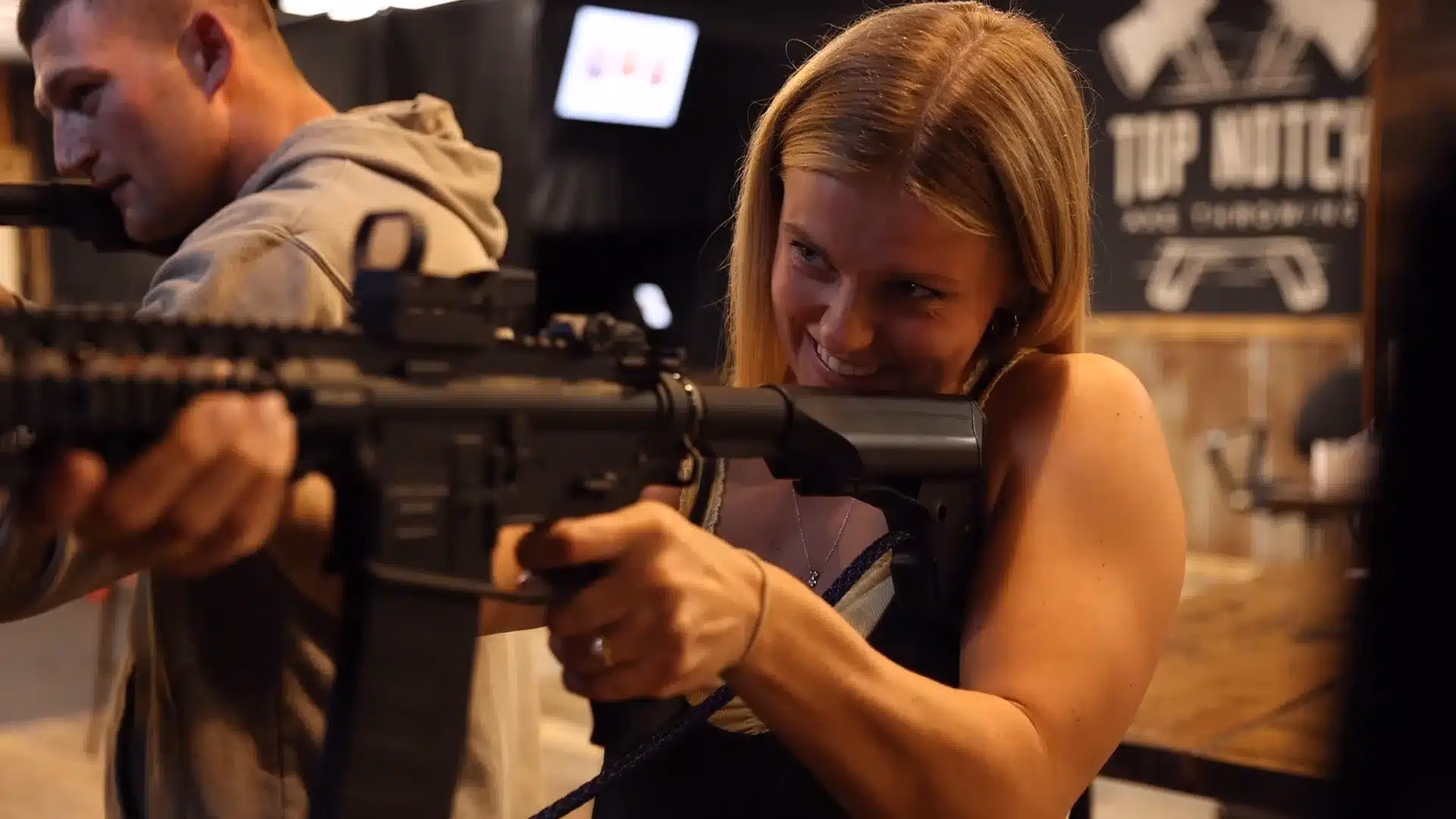 A guest lining up a shot with an AR-style BB rifle at Top Shot